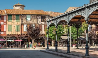 Centre-ville animé de Mirepoix, en France, où habitants et visiteurs se promènent au milieu de bâtiments historiques à colombages. Centre-ville animé de Mirepoix, en France, où habitants et visiteurs se promènent au milieu de bâtiments historiques à colombages.