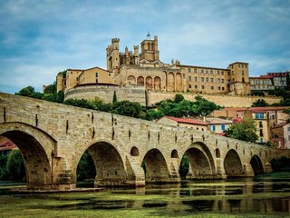 Rustig tafereel langs het Canal du Midi met een door bomen omzoomde waterweg en wandelaars die het dagelijks leven in Occitanië weerspiegelen.