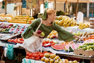 Journée de marché animée à Mirepoix avec des étals colorés, des produits locaux et des bâtiments médiévaux à colombages