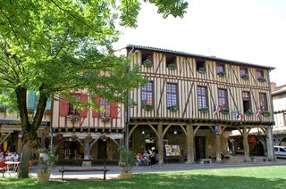 Lively Mirepoix market with locals shopping for fresh produce among historic half-timbered buildings in Ariège Lively Mirepoix market with locals shopping for fresh produce among historic half-timbered buildings in Ariège