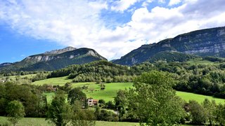 Maisons rurales dans la campagne ariégeoise entourées de collines, de champs et de paysages naturels paisibles