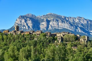 La vie traditionnelle dans un village de montagne des Pyrénées en Occitanie : des maisons en pierre, des rues paisibles et une culture rurale à la française.