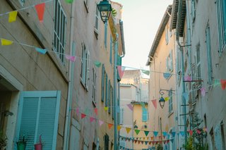 Colourful bunting lining the streets is a hallmark of village fêtes in France, creating a festive atmosphere that welcomes locals and visitors alike.
