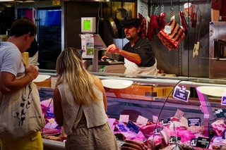Des clients achetant de la viande fraîche sur un marché de village traditionnel dans le Gers, en France. Des clients achetant de la viande fraîche sur un marché de village traditionnel dans le Gers, en France.